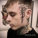 Фото тату в стиле Blackwork на лице мужчины. Изображение змеи, обвивающей медицинский символ, выполнено черными линиями и точками.