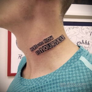 Фото тату надписи 'HERE AND NOW BE YOURSELF' на шее, выполненное черными блочными буквами.