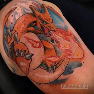 Фото татуировки на плече с изображением покемона Charizard, извергающего пламя. Яркие цвета и детализированная проработка в стиле аниме.