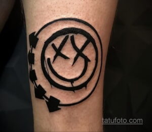 Фото тату логотипа Blink-182 на ноге. Черно-белый рисунок, символизирующий любовь к музыке и группе.
