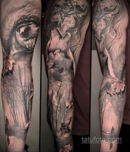 Фото масштабной татуировки волка в лесу на руке. Изображение выполнено в черно-серых тонах, с высокой детализацией и реалистичными тенями.