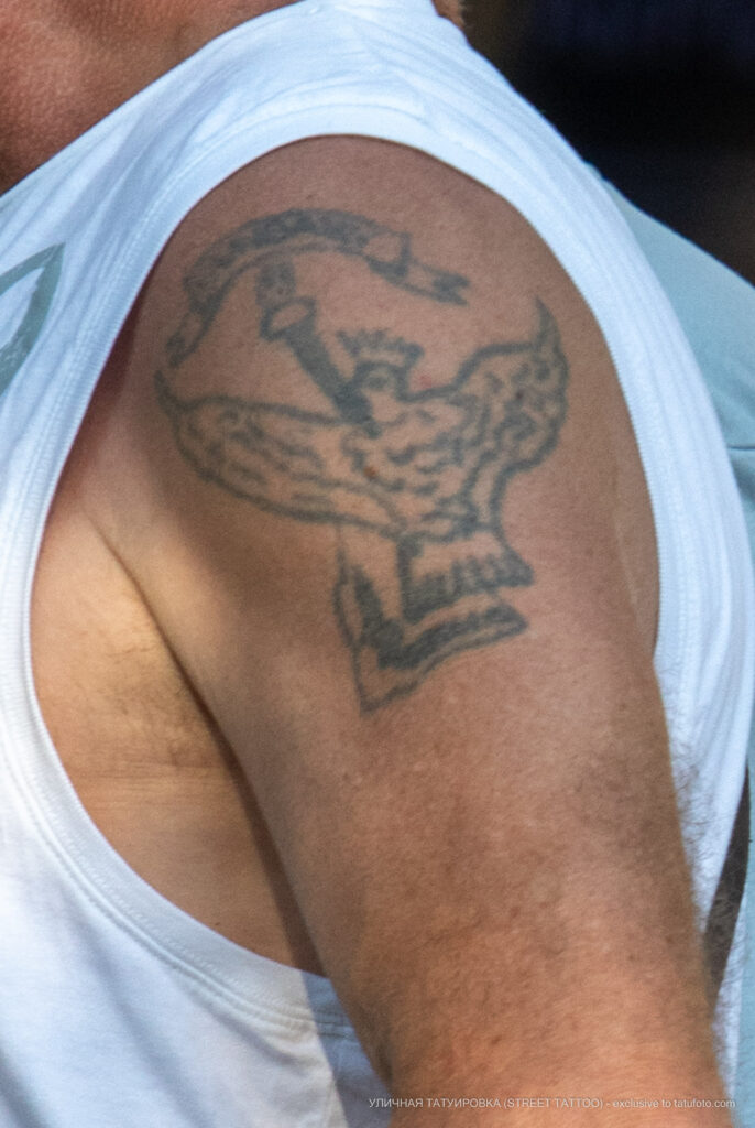 Старая армейская тату с факелом, надписью и птицей на левом плече пожилого мужчины – Фото Уличная тату (street tattoo) № 13 – 27.06.2021 3