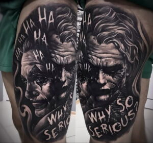 Фото тату на спине, изображающее лицо Джокера с надписью "WHY SO SERIOUS?". Реалистичный черно-белый портрет с детальной проработкой.
