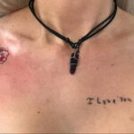 Фото тату на груди: реалистичные изображения розы и подсолнуха с надписью 'I love you mostest', выполненные в акварельной технике.