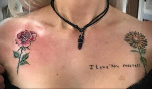Фото тату на груди: реалистичные изображения розы и подсолнуха с надписью 'I love you mostest', выполненные в акварельной технике.