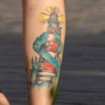Цветная тату с маяком на правой ноге у девушки – Фото Уличная тату (street tattoo) № 13 – 27.06.2021 1