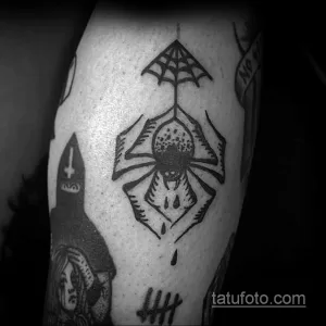 Фото тату паука в геометрическом стиле Blackwork на руке. Рисунок выполнен полностью черным цветом, с использованием четких линий и геометрических фигур.