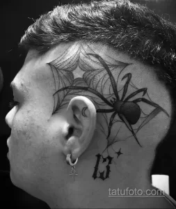 Фото тату паука в паутине на голове. Рисунок выполнен в технике blackwork с использованием только черного цвета.