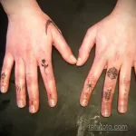 Фото миниатюрных тату на пальцах: паук, роза, коса и череп. Татуировки выполнены тонкими черными линиями.