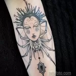 Фото тату женщины с паучьими лапами на руке, выполненное в стиле blackwork. Оригинальный и загадочный дизайн.