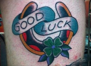 Фото татуировки подковы с надписью "GOOD LUCK" и четырехлистным клевером. Яркий и символичный рисунок тату.