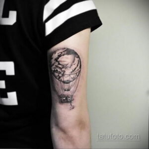 Фото тату на предплечье: реалистичный черно-белый воздушный шар с облаками внутри. Элегантный и стильный рисунок татуировки, выполненный в технике графики.
