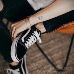 Фото тату контура камеры на запястье. Простой, минималистичный рисунок в черном цвете.