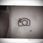 Фото тату минималистичного контурного рисунка фотоаппарата на запястье. Простой и стильный эскиз татуировки.