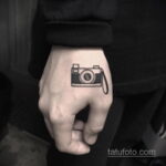 Черно-белое фото минималистичной татуировки фотоаппарата на руке. Простой контурный рисунок, идеально подходит для любителей фотографии.