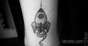Фото тату на руке: черно-белая ракета, выполненная в технике dotwork. Детализированный эскиз тату для ценителей графики.