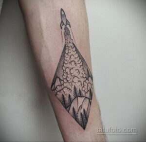 Фото тату на руке: геометрическая татуировка с изображением ракеты, взлетающей над горным пейзажем. Стильный и минималистичный рисунок татуировки.