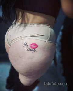 Фото тату с надписью "Yes Daddy" и изображением красных губ на спине. Татуировка выполнена в минималистичном стиле.