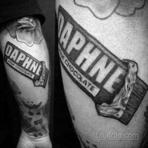 Фото тату в стиле олдскул, изображающее шоколадку Daphne Milk Chocolate. Расположена на предплечье, черно-белый рисунок татуировки.
