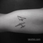 Фотография татуировки на руке, изображающей самолет и бумажный самолетик. Маленький, изящный рисунок, выполненный в технике дотворк.