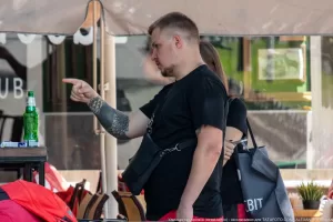 Фото тату на руке мужчины, указывающего пальцем в сторону. Татуировка выполнена в темных тонах и покрывает большую часть предплечья.