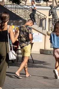 Фотография уличной татуировки с изображением дракона на ноге, сделанная в движении. Рисунок выполнен в ярких цветах и демонстрирует детализированную проработку.