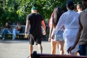 Фото тату: рука мужчины с детализированной татуировкой на предплечье, идущего рядом с девушкой.