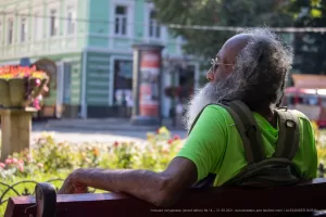 Фото татуировки на шее мужчины с длинной седой бородой. Рисунок выполнен в черном цвете, детализированный и символичный.