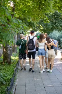 Фотография группы людей на улице, у которых видны татуировки на руках и ногах. Татуировки выполнены в различных стилях и имеют разнообразные сюжеты.