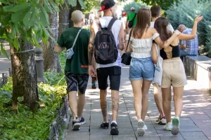 Фотография группы людей на улице, у которых видны татуировки на руках и ногах. Татуировки выполнены в различных стилях и имеют разнообразные сюжеты.