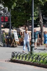 Фото тату: крупный план мужской руки с татуировкой в виде рукава. Рисунок включает в себя черепа, цветы и геометрические узоры.