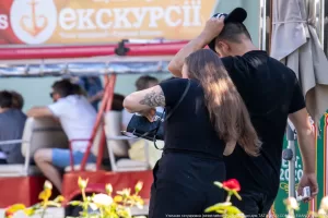 Фото тату на руке девушки, сидящей в кафе. Черно-серый рисунок в стиле графика, изображающий птицу. Детализированный эскиз татуировки.