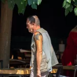 Фото тату на руке мужчины: рукава с рисунками, детализированные узоры, реалистичный стиль, темные тона, уличная фотография.
