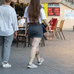 Фото татуировок на теле: небольшие цветки на плече, надпись на руке и цветок на ноге, выполненные в ярких цветах.