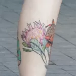 Тату большой цветок чертополоха и летающая тарелка с надписью внизу ноги девушки - Уличная тату (street tattoo) № 14–210821 8