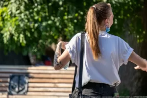 Фото тату на предплечье девушки, выполненное в стиле олдскул с использованием черных чернил. Видны детализированные элементы рисунка и четкие контуры.