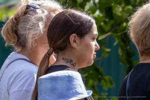 Фото тату на шее: крупный план арабской каллиграфии, выполненной черными чернилами. Татуировка расположена сзади, под волосами, демонстрируя детали и изящество рисунка.