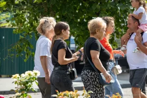 Фото тату на шее: арабская каллиграфия, выполненная черными чернилами. Татуировка расположена сзади, под волосами, создавая элегантный и загадочный образ. Женщина идет по улице.