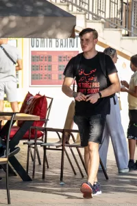 Фото тату на руке мужчины с арабской надписью и английским текстом 'Don't Shoot'. Уличная фотография, демонстрирующая современный стиль татуировки.