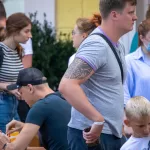 Фото тату в стиле трайбл на руке. Черно-серая татуировка с геометрическими узорами и сложной структурой.