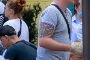 Фото тату в стиле трайбл на руке. Черно-серая татуировка с геометрическими узорами и сложной структурой.