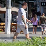 Фото тату на руке мужчины: надпись "Florence Life" в сочетании с абстрактными черными линиями. Стильный рисунок татуировки для вдохновения.
