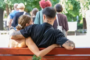 Фотография пары в объятиях, у мужчины татуировки на руке и шее, у женщины - на спине. Идеально для поиска идей для парных тату.