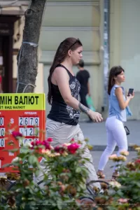 Фото тату на предплечье: реалистичный череп, увитый красными розами, выполненный в черно-серых тонах. Детализированный рисунок татуировки привлекает внимание.
