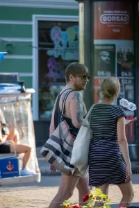 Фото тату на плече мужчины: реалистичный портрет женщины в черно-серых тонах, детализированный рисунок татуировки, мастерская работа.