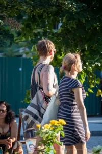 Фото тату на плече мужчины: реалистичный портрет женщины в черно-серых тонах, абстрактные элементы, уличная фотография, вид сбоку.