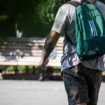 Фото тату на руке мужчины, выполненное в ярких цветах с использованием абстрактных узоров и цветочных мотивов. Рукав татуировки покрывает всю руку.