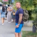 Фото тату на руке мужчины, рука с татуировкой, уличная фотография, современный стиль, татуировка с черепом и цветами, повседневный образ.