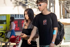 Фото тату с изображением лица на руке молодого человека. Черно-белый рисунок татуировки с реалистичной проработкой деталей лица и выразительным взглядом. Эскиз тату.