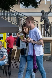 Фотография татуировки в виде рукава на руке, с изображением портрета женщины, реалистичных животных и надписей. Тату выполнено в черно-белой гамме с высокой детализацией.